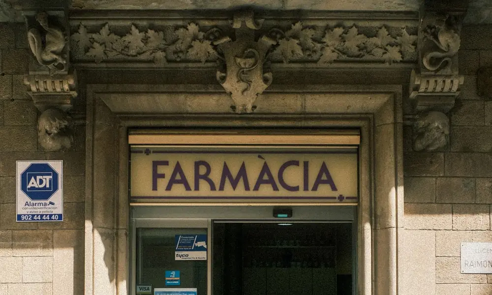 Entrada de una farmacia con su rótulo de Farmàcia sobre la puerta
