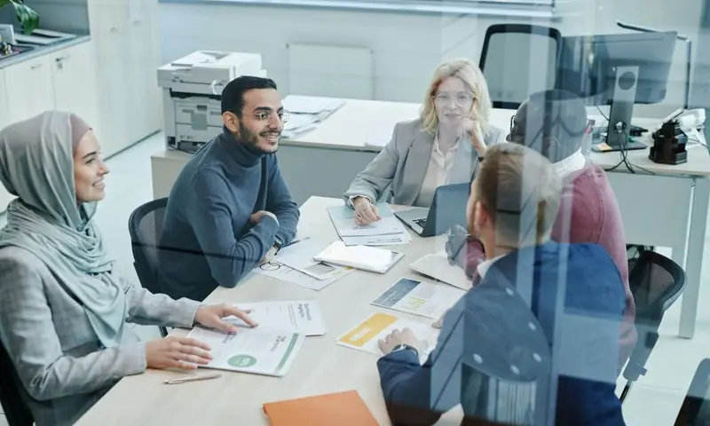 Un equipo de trabajo reunido alrededor de una mesa de oficina