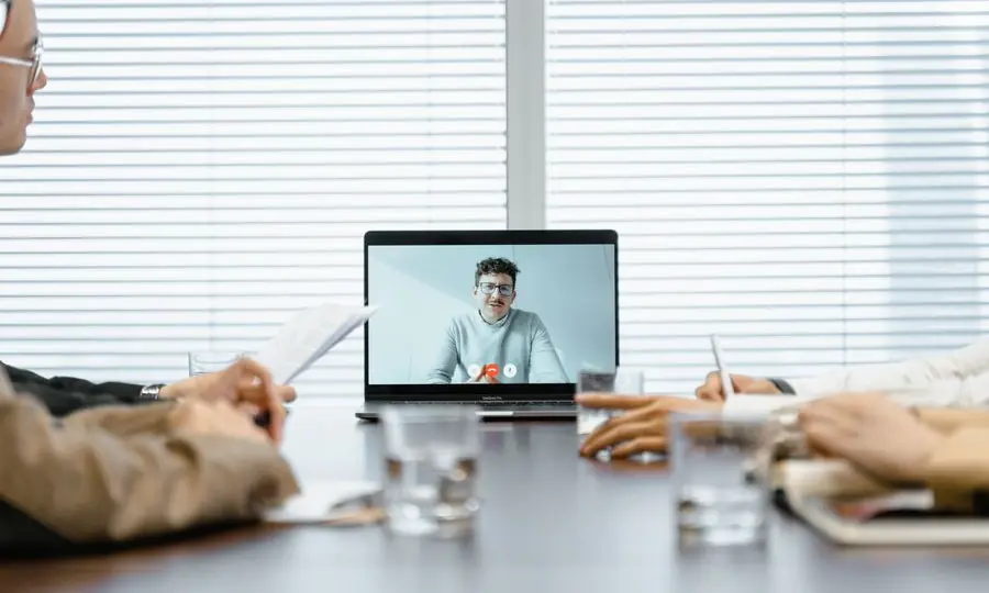 Varias personas en una sala atienden una videollamada